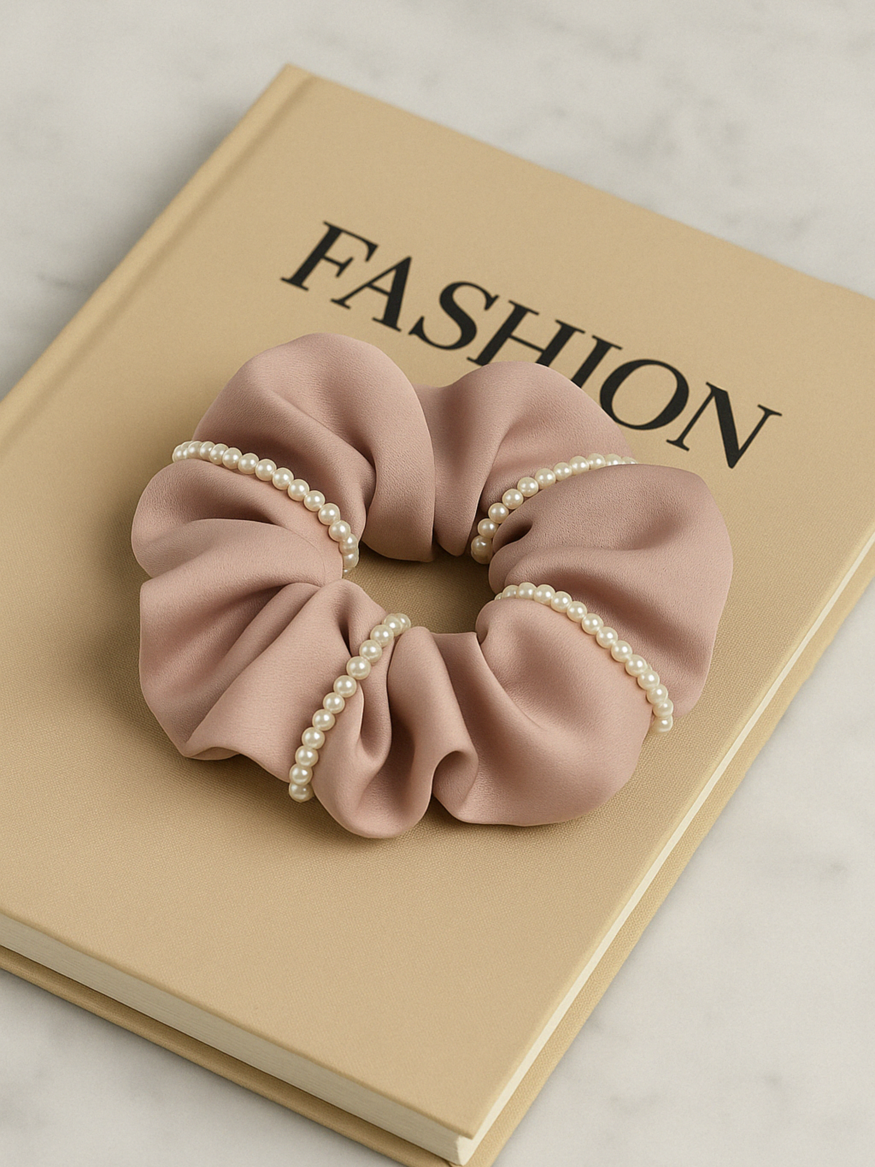 Chouchou rose en satin décoré de perles, accessoire tendance et raffiné pour cheveux longs ou courts.
